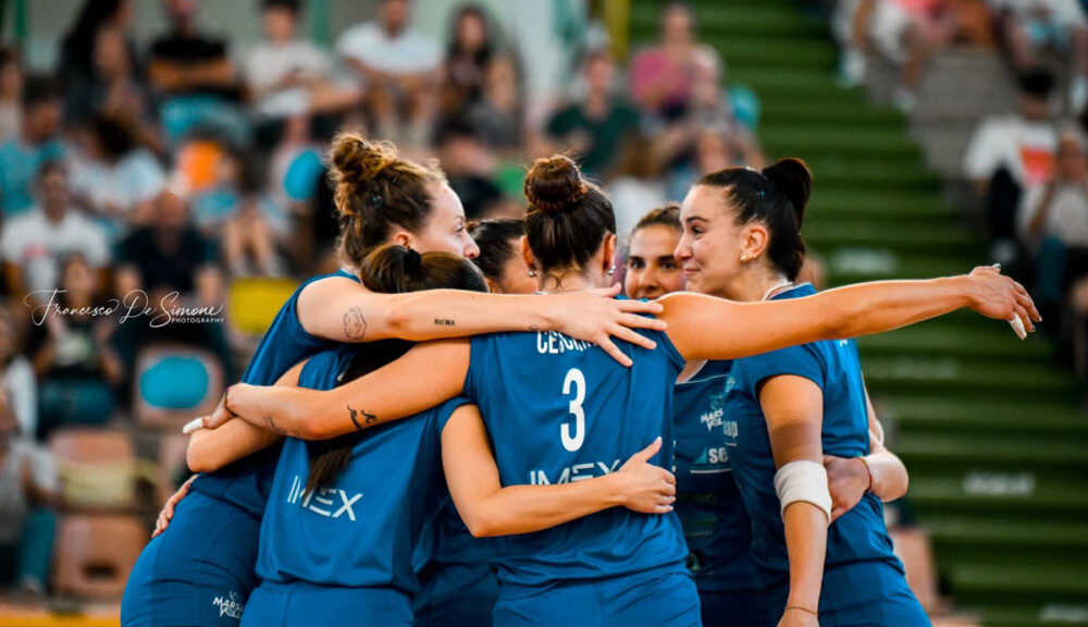 Giocatrici del Marsala Volley si abbracciano in campo dopo un punto, durante la finale playoff A2. Emozione e spirito di squadra al massimo.