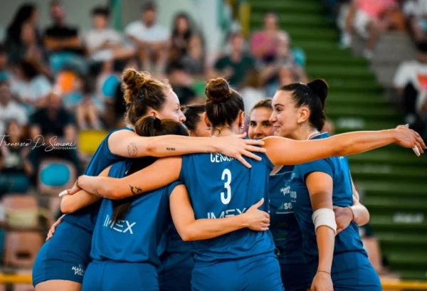 Giocatrici del Marsala Volley si abbracciano in campo dopo un punto, durante la finale playoff A2. Emozione e spirito di squadra al massimo.