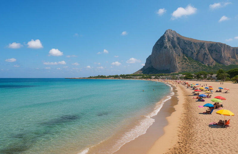 Spiaggia di San Vito Lo Capo con mare calmo, cielo sereno e Monte Monaco sullo sfondo in una luminosa giornata estiva