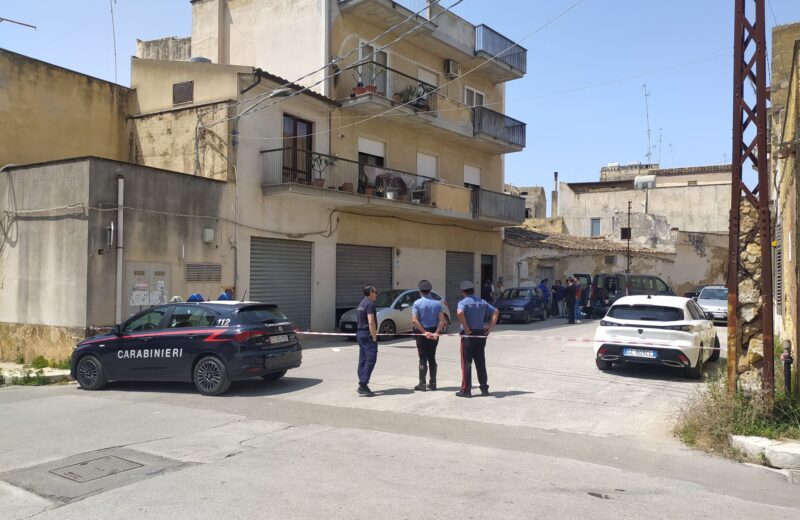 Scena del crimine a Castelvetrano con carabinieri e nastro di sicurezza davanti a una palazzina in via IV Aprile, luogo dell'omicidio-suicidio