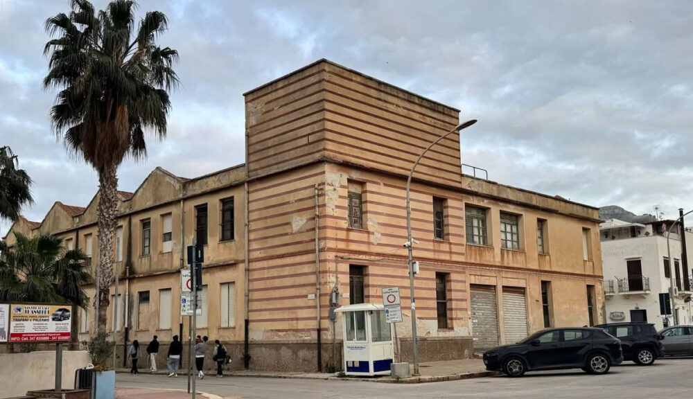 Edificio dell’ex Colonia di Padre Campanile a San Vito Lo Capo, con facciata a righe e cielo nuvoloso