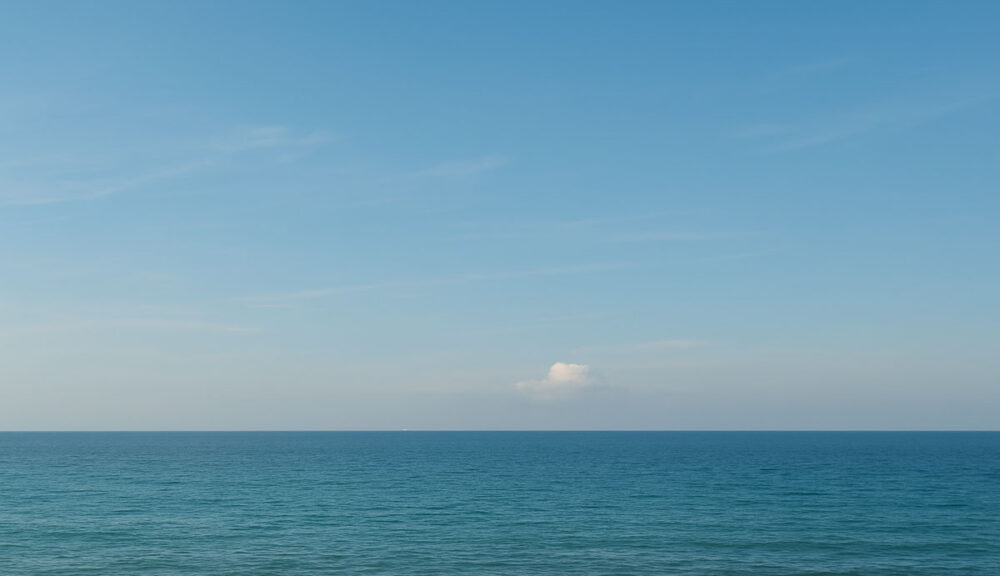 Mare calmo sotto un cielo sereno d’estate con orizzonte limpido