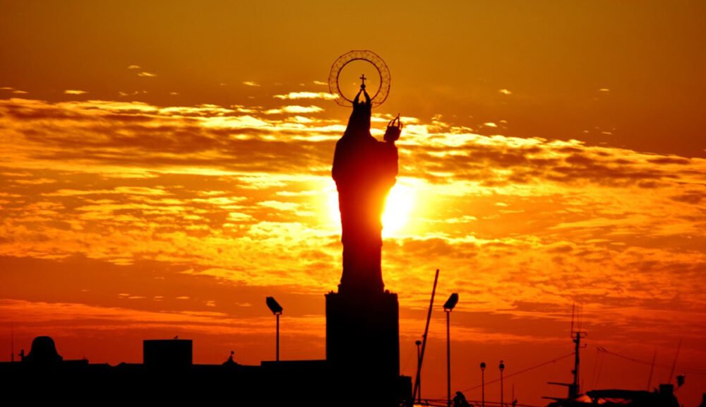 Tramonto a Trapani sulla statua della Madonna del Porto
