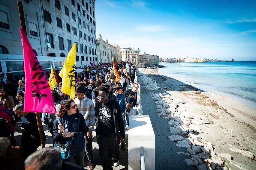 Manifestazione sul lungomare di Trapani con bandiere colorate