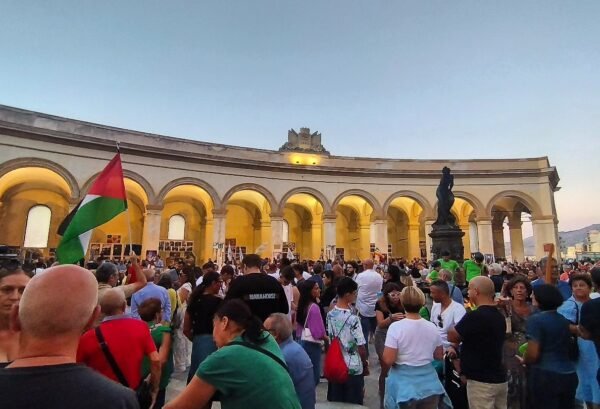 Manifestazione in Piazza Mercato del Pesce a Trapani con folla e bandiere