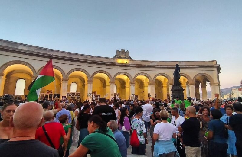Manifestazione in Piazza Mercato del Pesce a Trapani con folla e bandiere