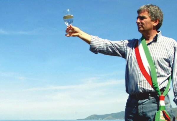 Angelo Vassallo, sindaco con fascia tricolore e calice alzato sul mare