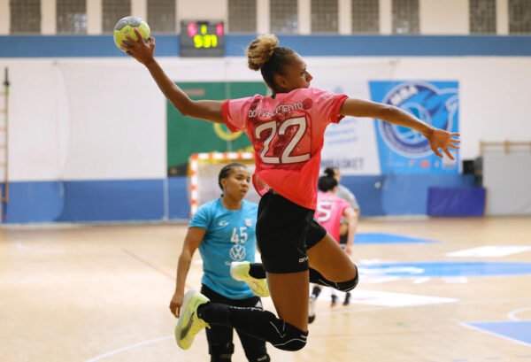 Giocatrice di pallamano in salto durante una partita al Pala Cardella di Erice